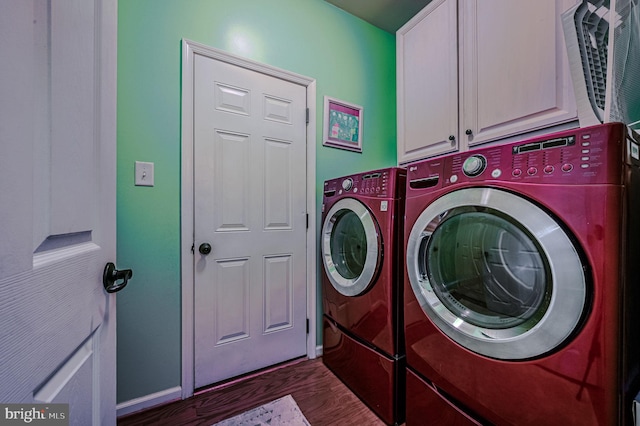 clothes washing area with cabinets, dark hardwood / wood-style floors, and washer and clothes dryer