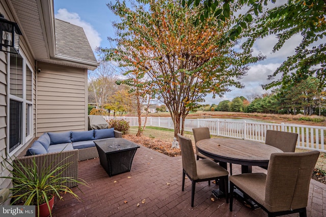 view of patio / terrace featuring a water view and an outdoor living space