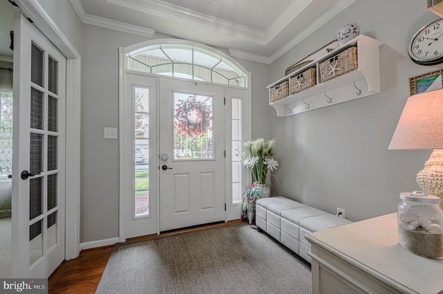 foyer entrance with a wealth of natural light, wood-type flooring, and crown molding