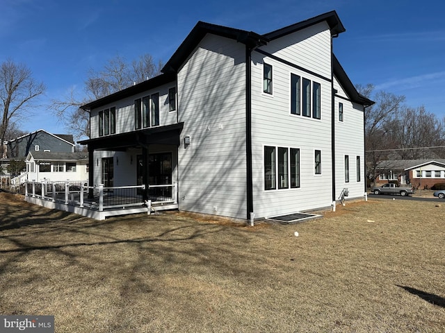 view of side of home featuring a porch and a lawn