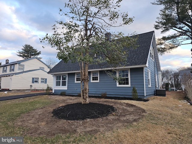 back of property with a lawn and central air condition unit