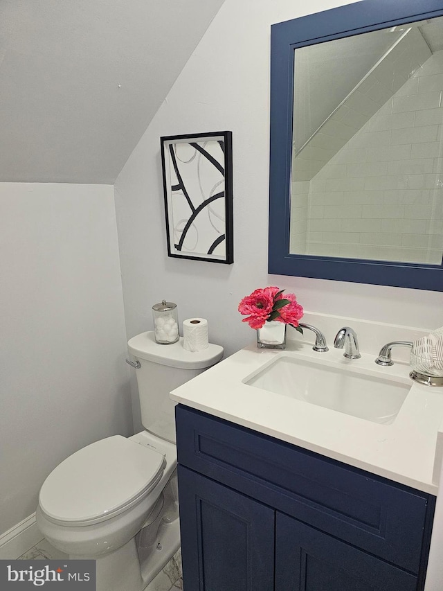 bathroom featuring toilet, lofted ceiling, and vanity