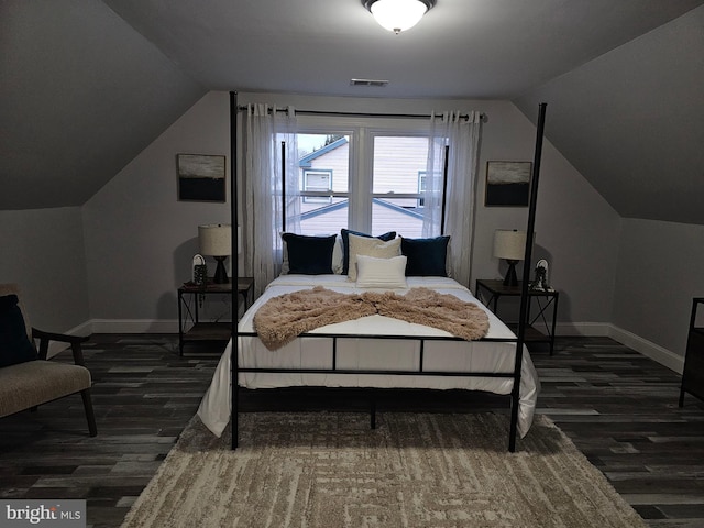 bedroom with dark hardwood / wood-style floors and lofted ceiling