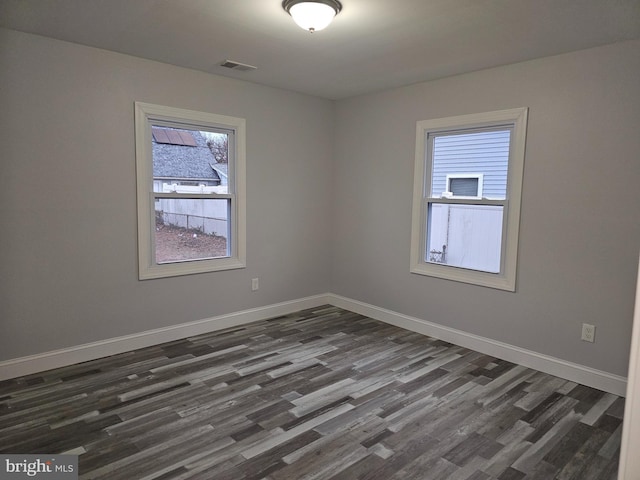 unfurnished room with dark hardwood / wood-style flooring