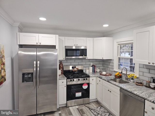 kitchen featuring sink, white cabinetry, appliances with stainless steel finishes, and tasteful backsplash