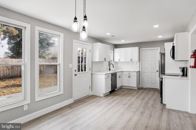 kitchen with white cabinetry, a healthy amount of sunlight, decorative light fixtures, and light hardwood / wood-style floors