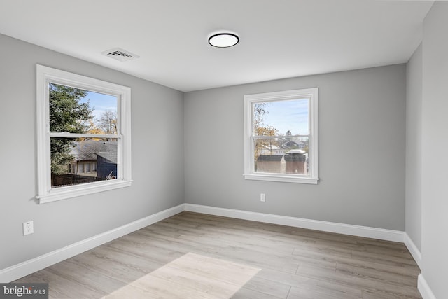 spare room featuring light hardwood / wood-style floors and a wealth of natural light