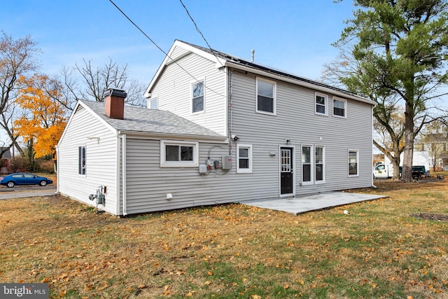 back of property with a patio area and a yard