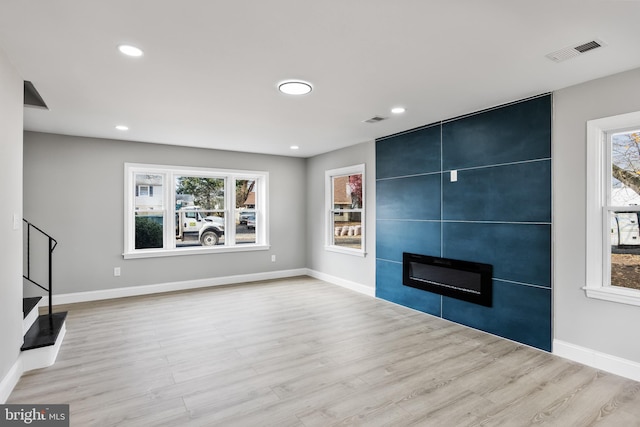 unfurnished living room featuring a fireplace and light hardwood / wood-style floors