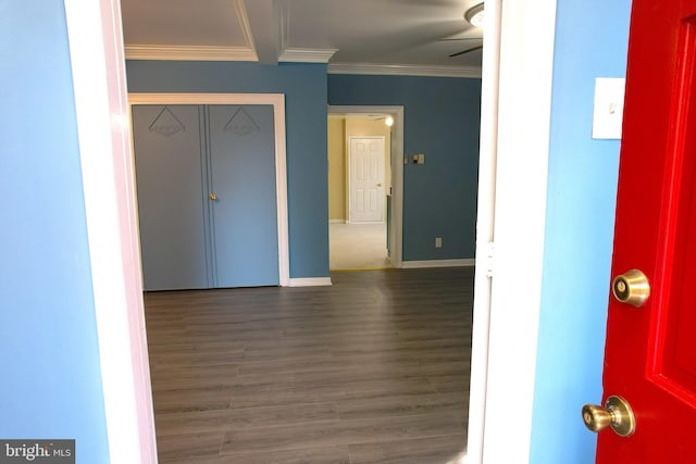 interior space with dark wood-type flooring, ceiling fan, and ornamental molding