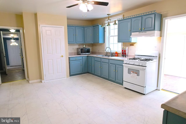 kitchen featuring white gas stove, sink, backsplash, ceiling fan, and decorative light fixtures