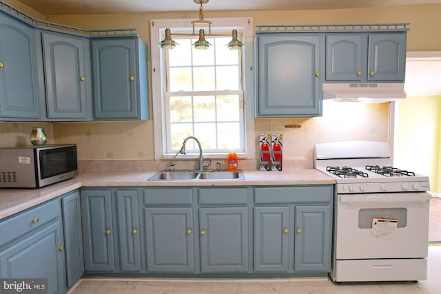 2810 Panther Rd, Vineland, NJ 08361 - kitchen with white gas range oven, a sink, under cabinet range hood, light countertops, and blue cabinets
