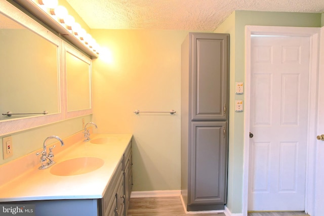 bathroom with vanity, hardwood / wood-style flooring, and a textured ceiling