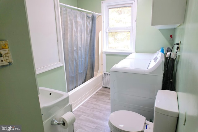 bathroom featuring separate washer and dryer, shower / bath combination with curtain, wood-type flooring, and toilet