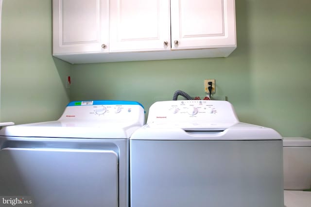 washroom featuring cabinets and washer and dryer