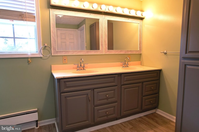 bathroom with vanity, hardwood / wood-style flooring, and baseboard heating