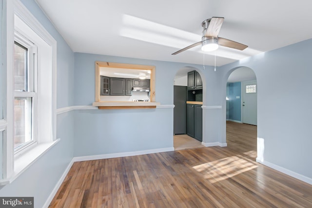 unfurnished living room featuring ceiling fan and hardwood / wood-style floors