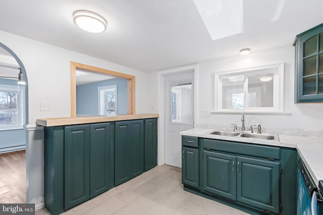 kitchen with light hardwood / wood-style flooring, baseboard heating, sink, and green cabinetry