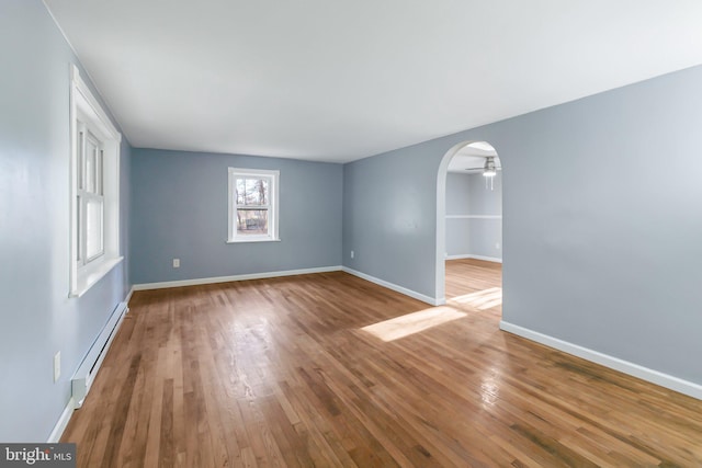 spare room with hardwood / wood-style flooring and a baseboard radiator