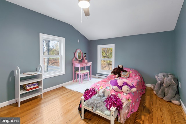 bedroom featuring multiple windows, hardwood / wood-style floors, lofted ceiling, and ceiling fan