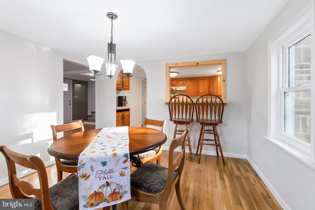 dining space featuring light hardwood / wood-style flooring and a notable chandelier