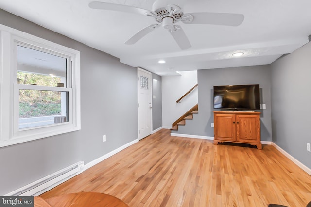 unfurnished living room with light hardwood / wood-style floors, a baseboard heating unit, and ceiling fan