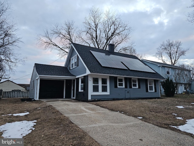 view of front of property featuring solar panels and a garage