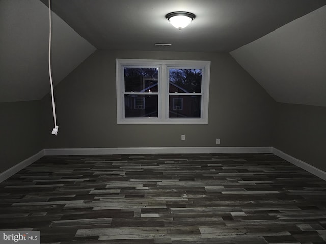 additional living space with dark wood-type flooring and lofted ceiling