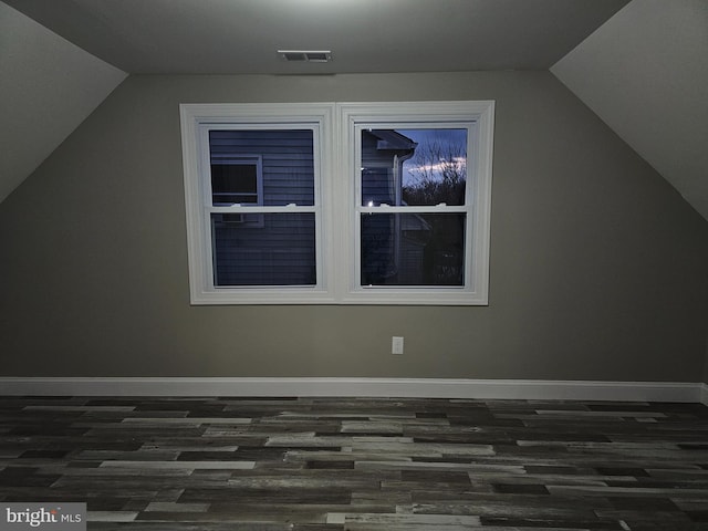 bonus room with dark wood-type flooring and lofted ceiling