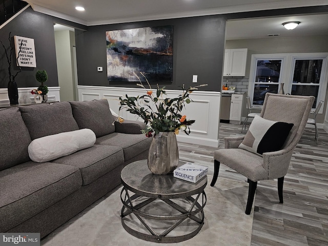 living room featuring light hardwood / wood-style floors and ornamental molding