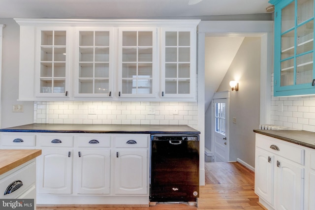 kitchen with white cabinetry, backsplash, light hardwood / wood-style flooring, lofted ceiling, and dishwasher