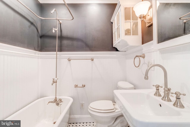 bathroom featuring a bathing tub, toilet, sink, and tile patterned floors