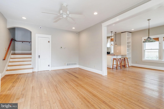 unfurnished living room featuring ceiling fan and light wood-type flooring