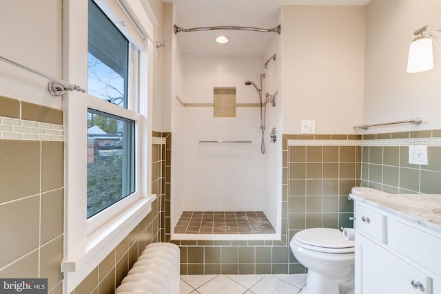 bathroom with radiator, vanity, tile patterned flooring, and plenty of natural light