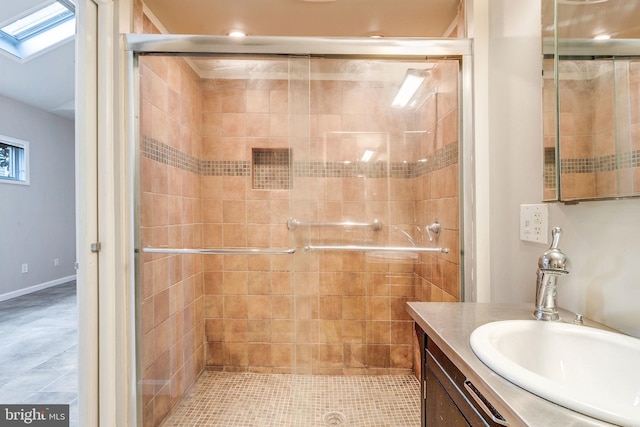 bathroom featuring walk in shower, vanity, tile patterned floors, and a skylight