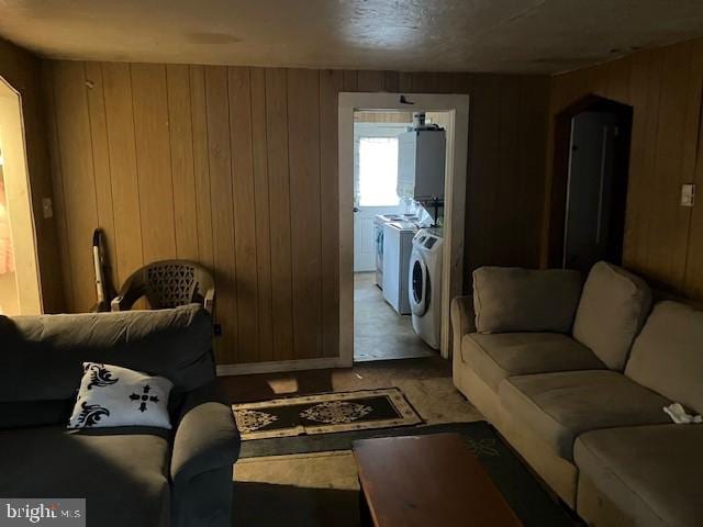 living room featuring wooden walls and independent washer and dryer