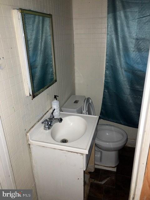 bathroom with tile patterned flooring, vanity, and toilet