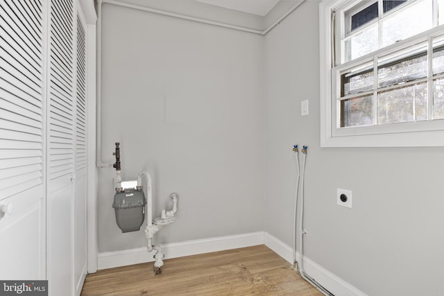 laundry room with hookup for an electric dryer and light wood-type flooring