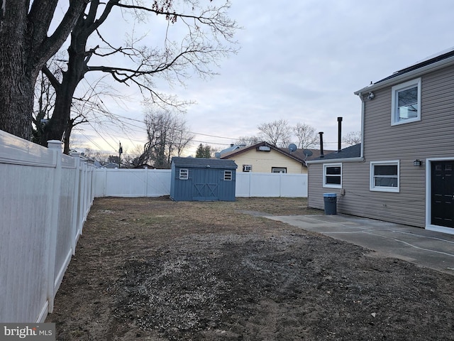 view of yard featuring a storage unit and a patio