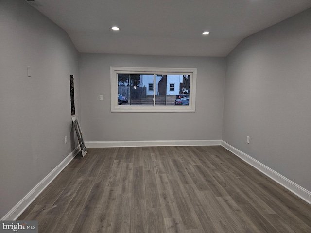 spare room with lofted ceiling and dark hardwood / wood-style floors