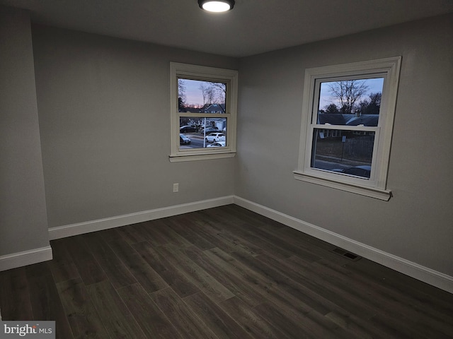 spare room with dark hardwood / wood-style floors