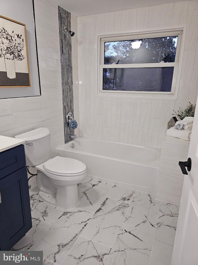 full bathroom featuring vanity, toilet, tile walls, and tiled shower / bath combo