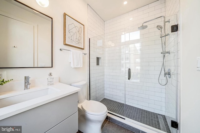 bathroom featuring vanity, tile patterned flooring, toilet, and walk in shower