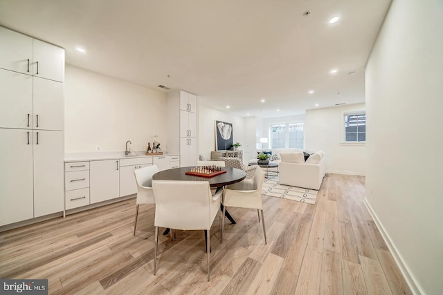 dining area with light hardwood / wood-style floors and sink