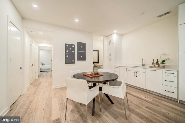 dining space featuring light hardwood / wood-style floors and sink