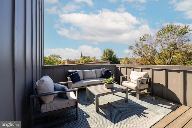 wooden terrace with an outdoor living space