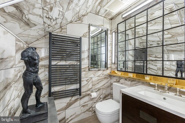 bathroom with vanity, toilet, tile walls, and radiator heating unit