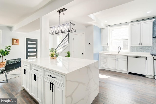 kitchen with a center island, decorative light fixtures, white dishwasher, and dark hardwood / wood-style flooring