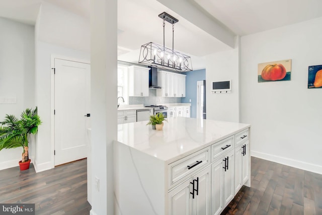 kitchen featuring gas stove, hanging light fixtures, white cabinetry, dark hardwood / wood-style floors, and wall chimney exhaust hood