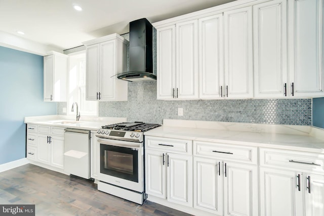 kitchen featuring wall chimney range hood, white cabinets, white dishwasher, gas range oven, and dark hardwood / wood-style floors